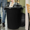 Plastic dustbin with locking lid in use for everyday household waste