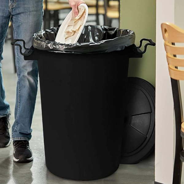 Plastic dustbin with locking lid in use for everyday household waste